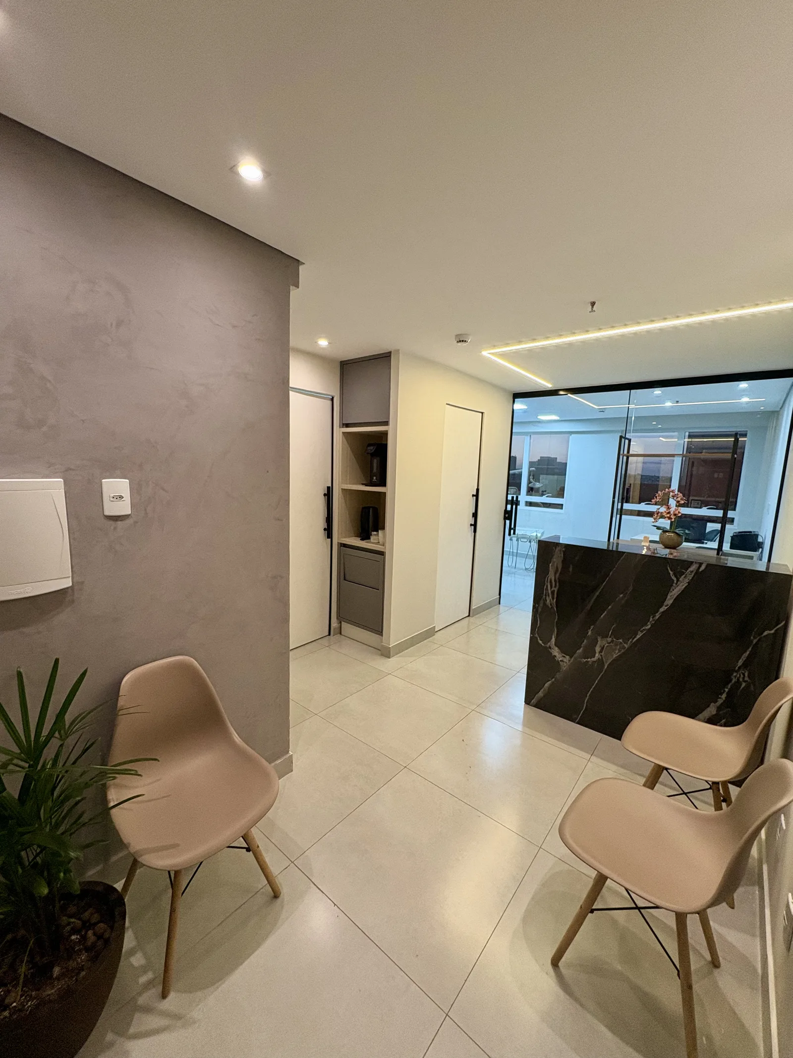 Recepção clara da Humanitate com poltronas, planta e balcão